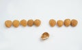 Nine Good almonds nut in a line and one bad almond on white background Royalty Free Stock Photo