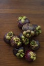 Nine mangosteen fruits on wooden table.