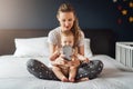 Nine-month-old baby girl sits with her mother and looks on smartphone cartoons. Child is talking to her grandmother via video link Royalty Free Stock Photo