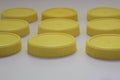 Nine plastic yellow round lid jars on a white background