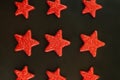 Nine red stars on black background. Flat lay. View from above. Day of the defender of Fatherland. The day of Soviet and Russian