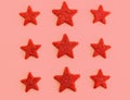 Nine red stars on pink background. Flat lay. View from above. Day of the defender of Fatherland. The day of Soviet and Russian