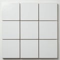 Nine white square tiles arranged in a three-by-three grid on a flat surface. Each tile has Royalty Free Stock Photo