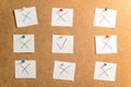 Nine white stickers for notes with x and v signs on a cardboard