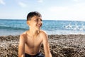 A nine-year-old boy is depicted at the beach, completely soaked. Royalty Free Stock Photo