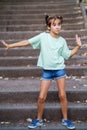 Nine-year-old girl dancing on the steps outdoors