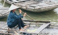 Ninh Binh, Vietnam - May 2019: Vietnamese woman in a wooden rowing boat going through Trang An nature park