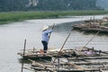 Ninh Binh, Vietnam - May 2019: Vietnamese woman in a wooden rowing boat going through Trang An nature park