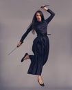 Ninja, swords and woman samurai in a studio jumping for a martial arts or assassin fighter skill. Fantasy, cosplay and Royalty Free Stock Photo