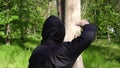 Ninja throws throwing stars shurikens into a tree. A ninja is training to throw a shuriken.