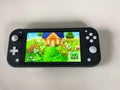 A Nintendo Switch Lite with the game Animal Crossing New Horizons running on it Royalty Free Stock Photo