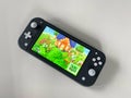 A Nintendo Switch Lite with the game Animal Crossing New Horizons running on it Royalty Free Stock Photo