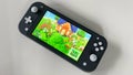 A Nintendo Switch Lite with the game Animal Crossing New Horizons running on it Royalty Free Stock Photo