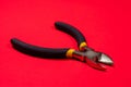 Nippers on a red background tool for cutting wires, cables and wire, for the electrician. The needle nose pliers Royalty Free Stock Photo