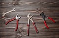 Nippers, wrench keys, pliers on a wooden table.