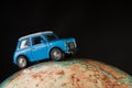 NIS, SERBIA - JANUARY 8 2018 Miniature figure toy car Mini Morris on geographical globe of earth on black background in studio Royalty Free Stock Photo