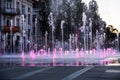 Fountain on the town square with purple water in a sunset