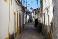 Woman walking along a narrow cobblestone street in the village of Nisa, Alentejo Royalty Free Stock Photo