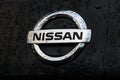 Nissan Logo on Nissan Rogue with Raindrops and Sky Reflection