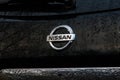 Nissan Logo on Nissan Rogue with Raindrops and Sky Reflection