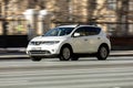 Nissan Murano car is driving in the cityscape. Front side view of white SUV in motion