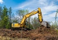 NISSWA, MN - 10 MAY 2023: Yellow excavator with bucket on a dirt pile Royalty Free Stock Photo