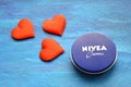 Nivea cream product and red hearts blue background Royalty Free Stock Photo