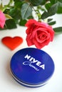 Nivea cream product and red rose white background