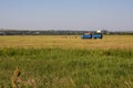 Nizhny Novgorod Region, Russia - July 8, 2020: Blue truck with a trailer carrying rolls of hay, autumn haymaking. Rural landscape Royalty Free Stock Photo