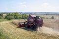 Nizhny Novgorod, Russia - July 17, 2021: A maroon harvester machine harvests rye from the field. Agricultural work on the farm Royalty Free Stock Photo