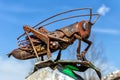 Monument to the grasshopper. Grasshopper from rusty metal sits on a rock