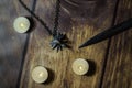 Nizhyn, Ukraine/ 22 December 2019: Flatlay, closeup of witcher Geralt`s medallion, knife and candles on the wooden background. Ne