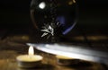 Nizhyn, Ukraine/ 22 December 2019: Medallion of the witcher Geralt hanging behind the crystal ball and knife above the candlelight