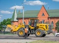 NIZHYN, UKRAINE - MAY 25, 2018: Workers repairing the road using yellow crawler asphalt paver in summer