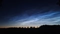 Nlc clouds in night sky with tree shadows Royalty Free Stock Photo