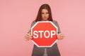 No access, way prohibited! Portrait of bossy brunette woman holding red traffic stop symbol, warning of danger