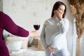 No alcohol during pregnancy. Young pregnant woman refuses to drink wine.