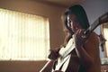 No audience required. a happy young woman playing her guitar while sitting on her bed. Royalty Free Stock Photo