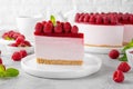 No baked raspberry cheesecake or raspberry cream mousse cake with jelly and fresh berries on top on a white plate on a gray Royalty Free Stock Photo