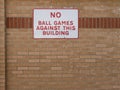 No Ball Game metal sign seen on a school brick wall. Royalty Free Stock Photo