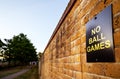 No Ball Games sign on a brick wall with path, trees and house Royalty Free Stock Photo