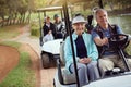 No better place to play. a smiling senior couple riding in a cart on a golf course. Royalty Free Stock Photo