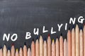 No bullying text on chalkboard with colorful pencils as border
