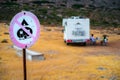 No camping sign with motorhome parked in the background