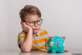 No cash money. Little caucasian kid banking money on piggy bank as wealth savings with angry face, negative sign showing Royalty Free Stock Photo