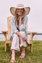 No clock, no problem. a beautiful young woman relaxing on a chair next a lake.