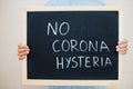 No corona hysteria. Coronavirus concept. Boy hold inscription on the board