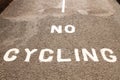 `No Cycling` painted in white on tarmac path.