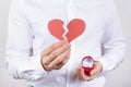 No date concept. Cropped closeup photo of confused unhappy sad guy holding showing broken heart in hand isolated grey background