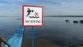 No Diving sign at beach, lake Naroch, Belarus. Warning sign of shallow water. Warning notice sign do not jump in water.